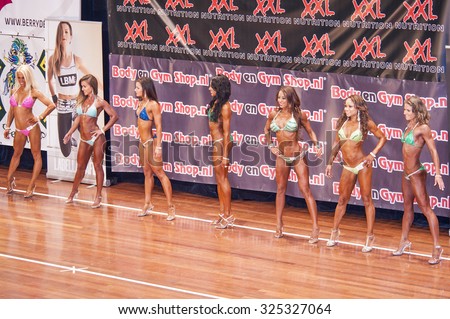 SCHIEDAM, THE NETHERLANDS - APRIL 26, 2015: Female bikini models show their best side on stage in a lineup comparison during competition at the Dutch National Championship Bodybuilding and Fitness