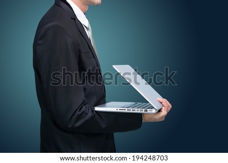 Businessman standing posture hand hold notebook laptop isolated on dark background