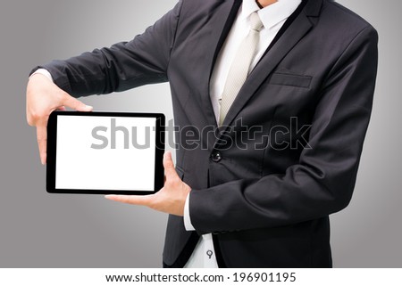 Businessman standing posture hand holding blank tablet isolated on over gray background