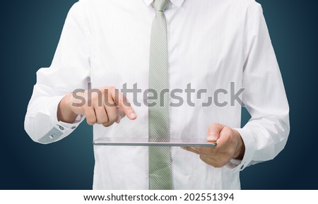 Businessman standing posture hand holding blank tablet isolated on dark background