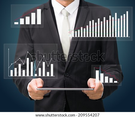Businessman standing posture hand hold graph on tablet on dark background