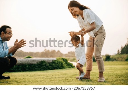 Similar – Image, Stock Photo Toddler learning to walk using push toy; child reaching to play with toy on front of walker