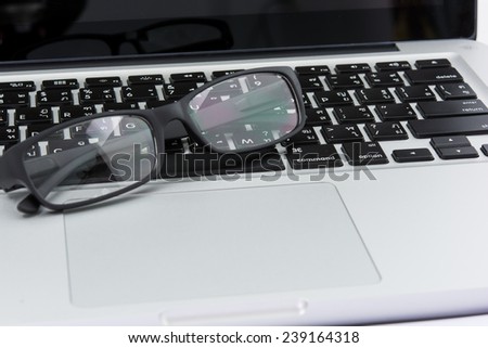 Blank business laptop, mouse and glasses on white table
