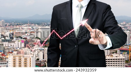 Businessman standing posture hand touch graph finance on City background