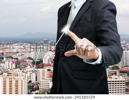 Businessman standing posture hand touch graph finance on City background