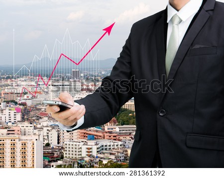 Businessman standing posture hand hold mobile phone analyze graph on City background
