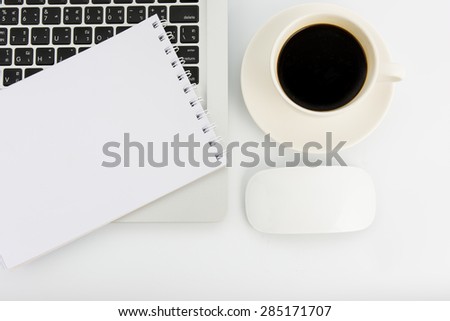Notebook laptop and coffee cup on white table