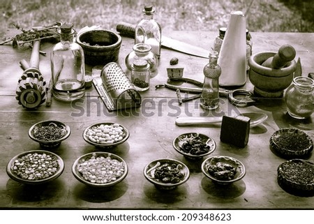 Nature\'s Pharmacy.  Vintage mortar and pestle surrounded by various herbs, ingredients and tonics.