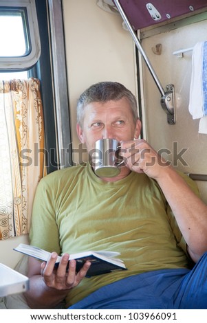 man goes in a train and reads the book