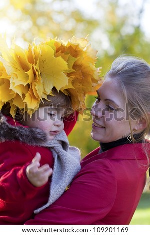Happy mother with the daughter walk in autumn park