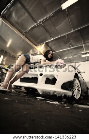 beautiful girl washes the car