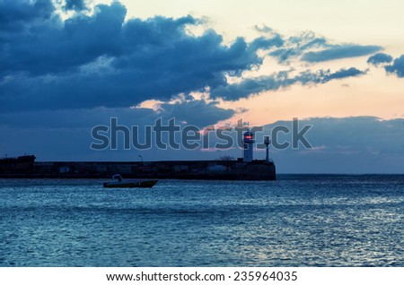 Beacon and the boat taking to the open sea at sunrise, Yalta