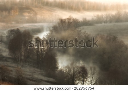 Surreal landscape with a river mist at sunrise in the early spring