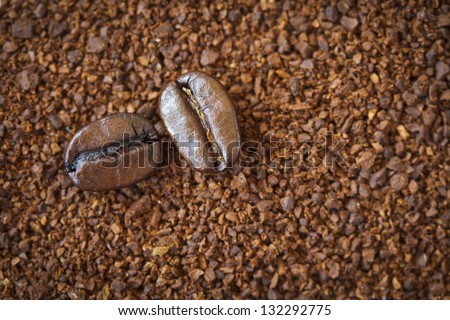 Two coffee beans on ground. Can be used as background. This beans are dark roasted for espresso.