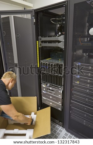 It engineer / consultant install / unpack a server or a network router / switch in a data center.