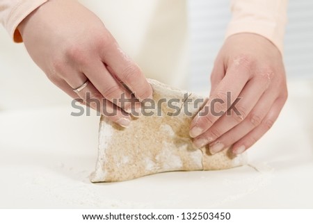 Girl baking with dough. Making fajitas or pizza. whole grain flour on the table.