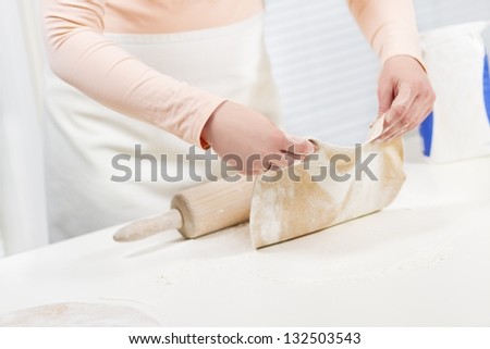 Girl baking and roll dough. Making fajita or pizza. whole grain flour on the table.