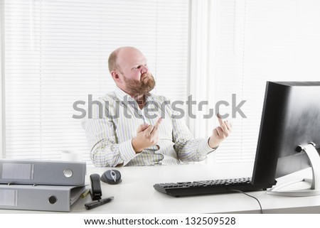 Angry office worker / businessman / it guy gives finger to his monitor.