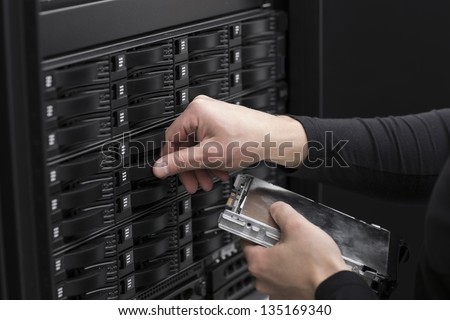 It engineer / technician working in a data center. This enclosures is a SAN (storage area network) and servers bellow.