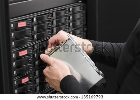 It engineer / technician working in a data center. This enclosures is a SAN (storage area network) and servers bellow.