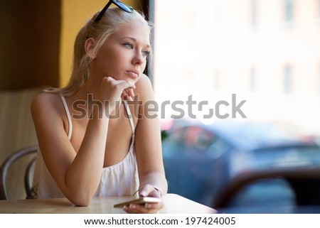 Thinking young woman looking out the window