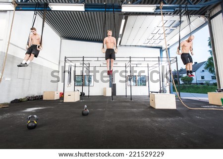 Three men exercise dips with rings