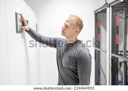 Engineer adjusts air conditioner in datacenter