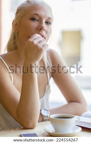 Young woman reading book at cafe