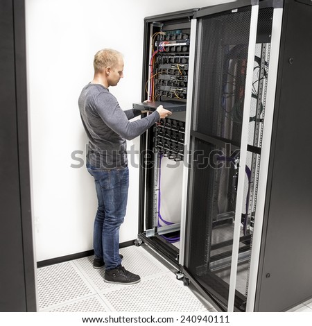 IT technician install network rack in datacenter
