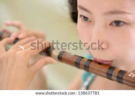 girl playing bamboo flute