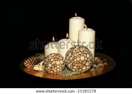 Original advent wreath with four burning candles isolated on a black background
