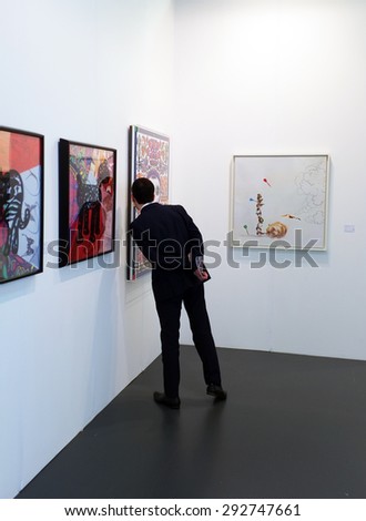 LONDON, UK - MAY 22, 2015: Visitor views an artwork in Art15, London\'s global art fair, held in Olympia\'s Grand Hall.