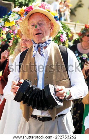 HASTINGS, UK - MAY 04, 2015: Man plays an old instrument during the parade of traditional Jack in the Green Festival in Hastings UK.