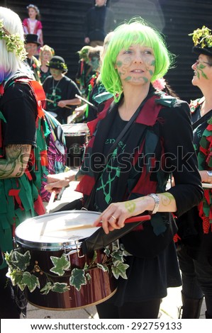HASTINGS, UK - MAY 04, 2015: Woman in costume plays drum during the parade of traditional Jack in the Green Festival in Hastings UK.