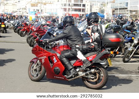 HASTINGS, UK - MAY 04, 2015: Couple in leather jacket ride their motorbike during the Biker\'s Festival which takes place in Hastings,UK