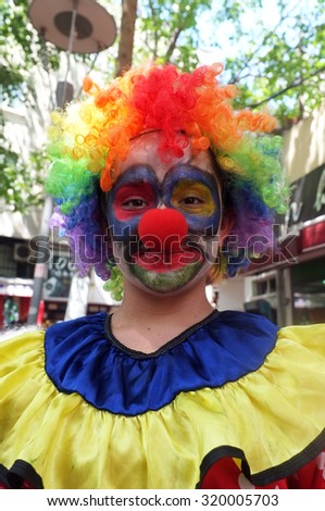 EDREMIT, TURKEY - AUGUST 14, 2015: Female street seller dressed as clown poses to the camera in Edremit, Turkey