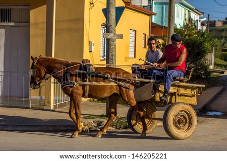 VINALES - FEBRUARY 4: Two young men on a cart on February 4, 2013 in Vinales, Cuba. Carts are very common type of transportation in Cuba as not everyone can afford to buy a car.