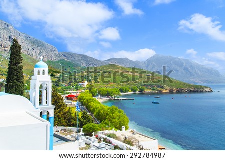 Typical Greek church with blue dome and sea bay in background, Greece