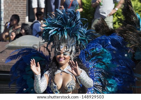 AMSTERDAM, THE NETHERLANDS - AUGUST 3, 2013: Sexy lady with blue feathers  dance in front of spectators at the famous Canal Parade of the Amsterdam Gay Pride 2013 on August 3, 2013 in Amsterdam