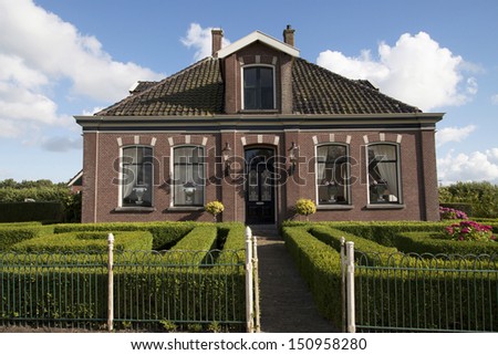 Old Dutch house with beautiful cut green hedge