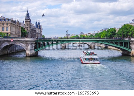 PARIS, FRANCE - JUNE 7: Seine, bridge Notre-Dame, and tourist boat, on June 7, 2009 in Paris, France. Les Halles area contains one of the largest underground modern shopping precincts in Paris.