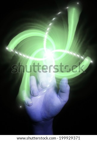 Hand pointing with  shiny colorful spiral on black background, as a concept metaphor of technology, science, and human feelings