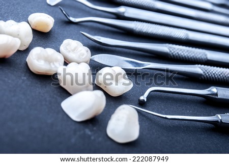 close up dental instruments and false teeth on black background