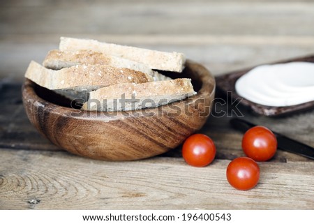 rustic meal, slices of bread, cherry tomatoes and cottage cheese on wood
