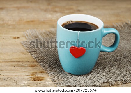 blue cup with red heart on grunge wooden vintage table