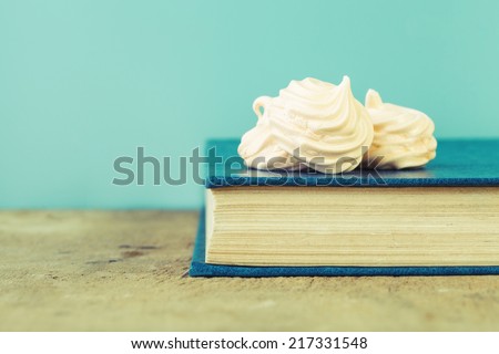 french meringue sweets on old blue book, vintage background
