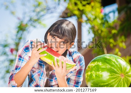 Healthy young woman-eating watermelon on a sunny day outside