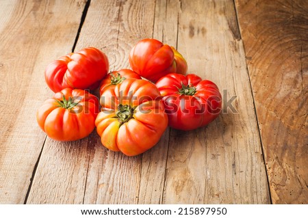 Red big tomatoes on a wooden rustic table in a beautiful day