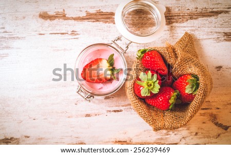 Wiosenne owoce, truskawki w lnianym worku z truskawkowym jogurtem na vintage drewnianym stole. Zdjęcia stock © 