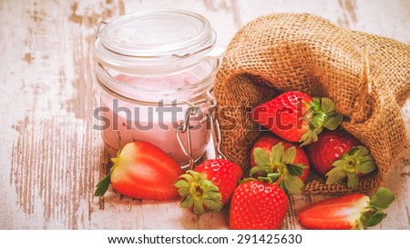Wiosenne owoce, truskawki w lnianym worku z truskawkowym jogurtem na vintage drewnianym stole. Zdjęcia stock © 